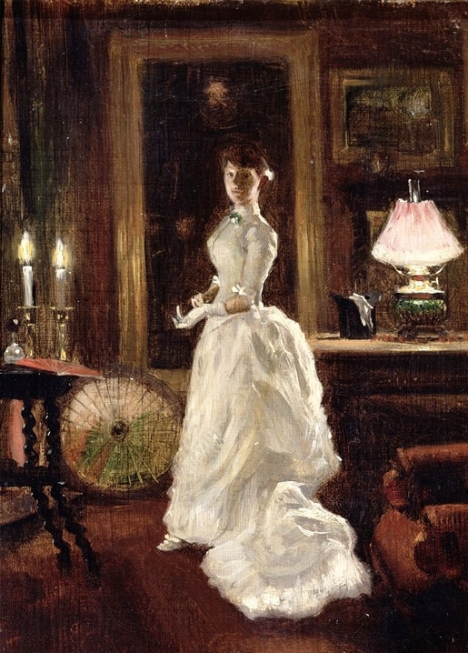 Woman in a white evening gown standing by candlelight and a rose-shaded lamp