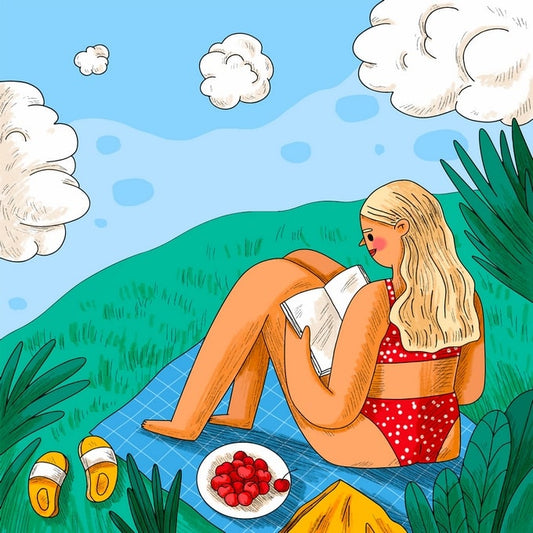 Woman reading a book on a picnic blanket with cherries and yellow sandals