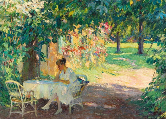Woman reading at a wicker table in the blossoming garden of an artist's villa on Lake Starnberg