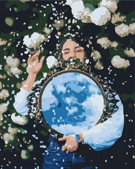 Frau mit rundem Spiegel, der einen bewölkten Himmel zwischen weißen Blüten reflektiert