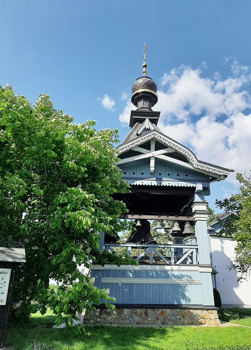 Wooden bell tower with onion dome and gold cross at Hryshko Botanical Garden, Kyiv