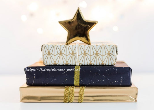 Gestapelte Weihnachtsgeschenke in goldenem und marineblauem Papier mit goldenem Stern obenauf