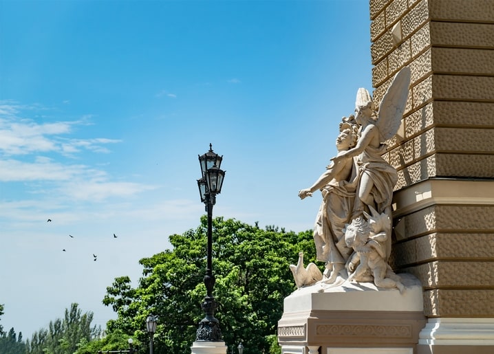 Скульптура ангела на розі будівлі з ліхтарем і птахами, Одеса
