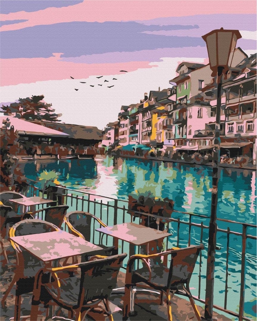 Café terrace in Antalya overlooking a canal under a pastel sunset sky
