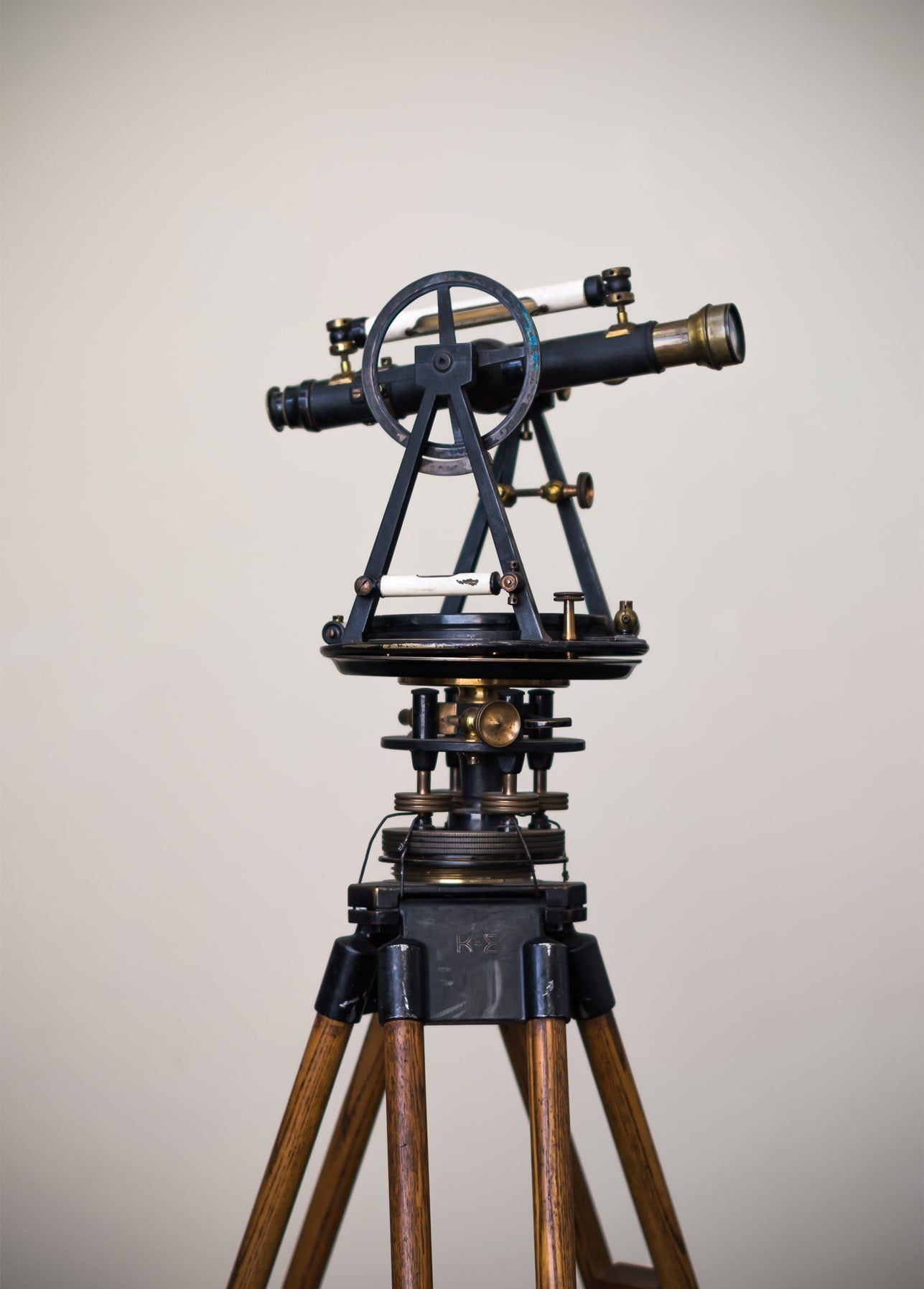 Antique brass theodolite with telescope mounted on a wooden tripod