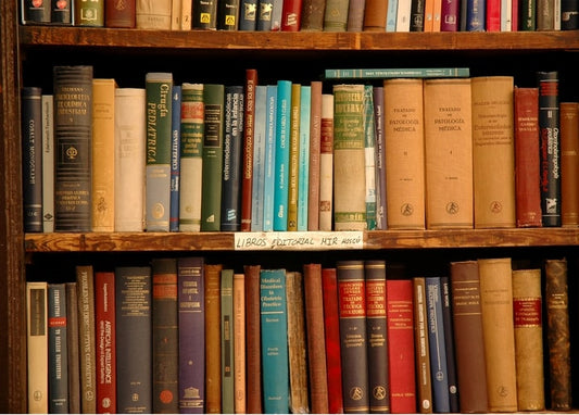 Старі наукові та медичні книги на темній дерев'яній полиці, одна поличка з написом «Libros Editorial Mir Moscú».