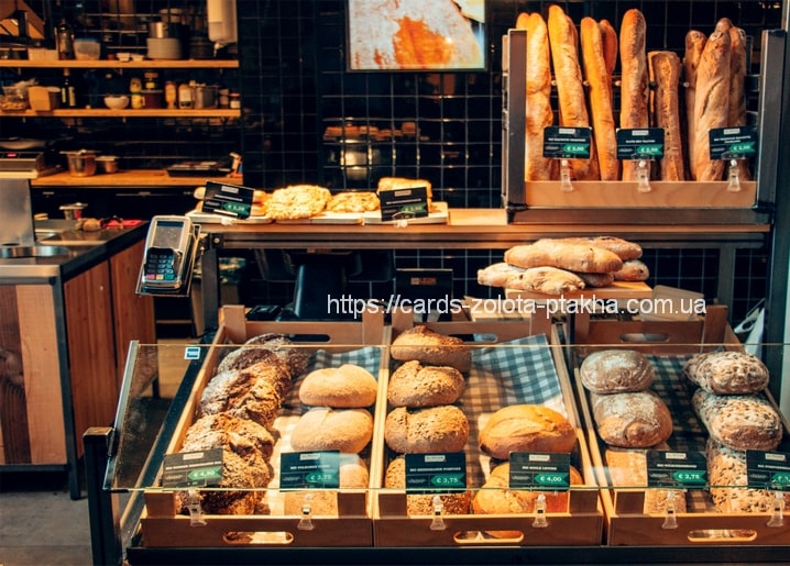 Bäckereivitrine mit Broten, Gebäck und aufrecht stehenden Baguettes im Regal