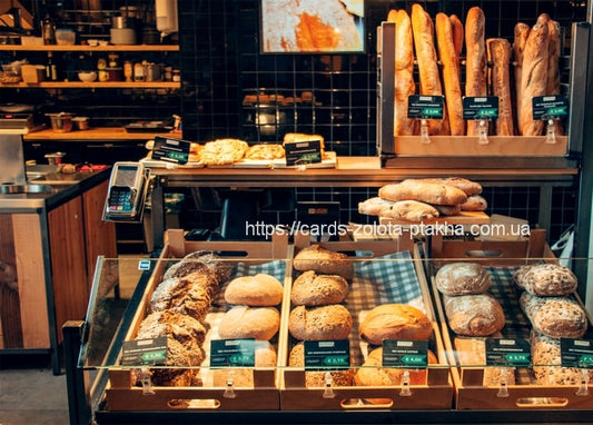 Bäckereivitrine mit Broten, Gebäck und aufrecht stehenden Baguettes im Regal