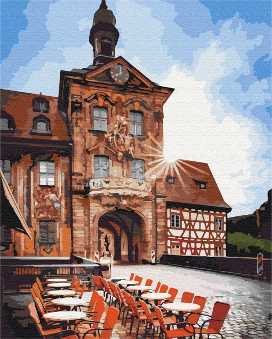 Bamberg's Altes Rathaus tower with orange café chairs on the cobblestone square
