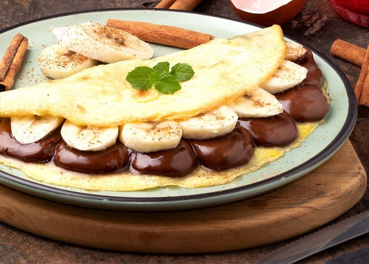 Млинець, згорнутий з бананом і шоколадним соусом