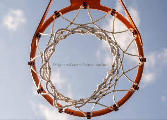 Basketballkorb mit Netz von unten vor blauem Himmel mit Wolken fotografiert