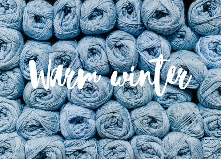 Blaue Wollknäuel mit dem Schriftzug „Warmer Winter“