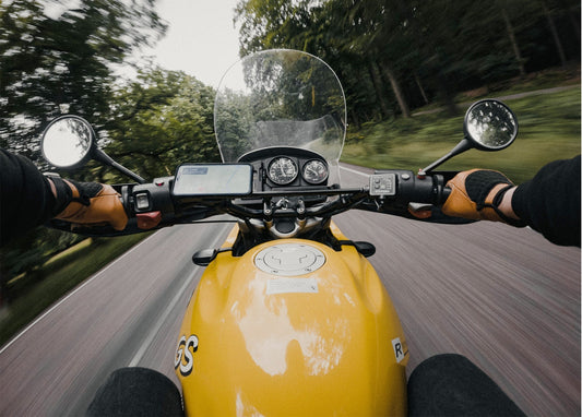 Ich-Perspektive vom Sattel einer gelben BMW GS auf einer Waldstraße