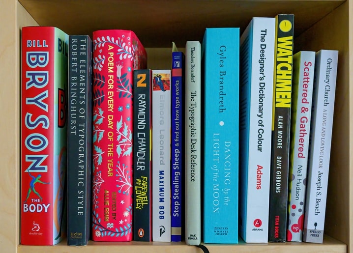Полиця зі світлого дерева з книгами з дизайну та яскравою графічною новелою