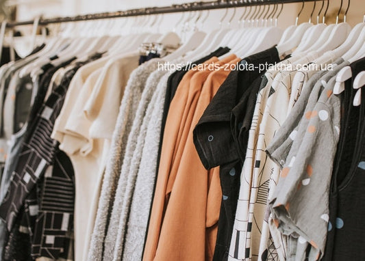 Nahaufnahme einer Boutique-Kleiderstange mit Schwarz-Weiß-Prints und bunter Strickware