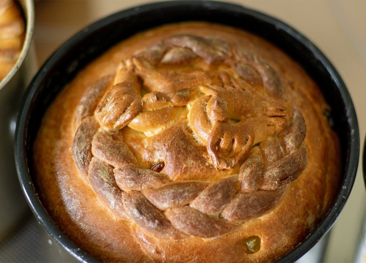 Close-up of a golden braided paska bread crown in a baking pan