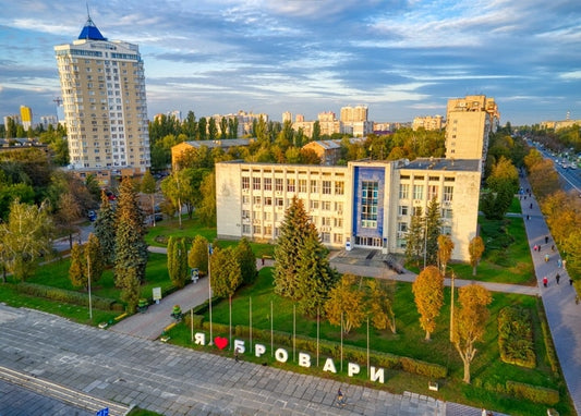 Luftaufnahme von Brovary mit beleuchtetem Schriftzug „Ich liebe Brovary“, Rathaus und Herbstpark bei Sonnenuntergang