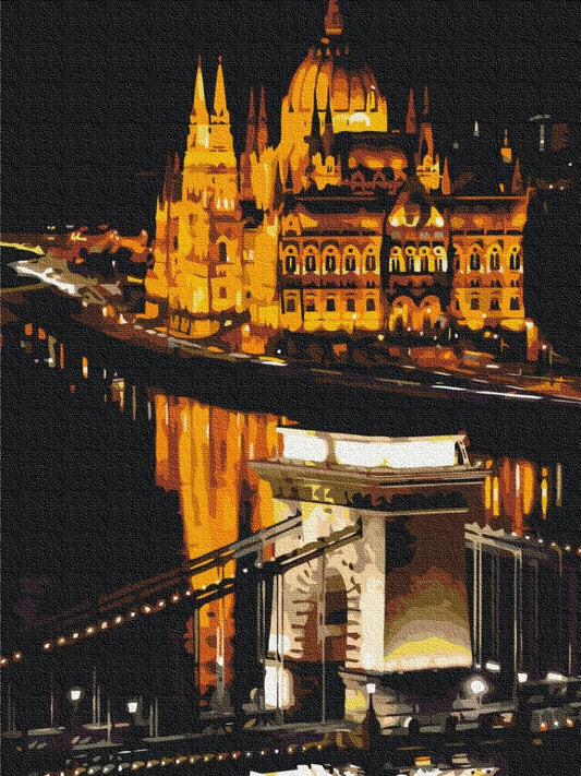 Illustration of Budapest's Parliament Building glowing at night beside the illuminated Chain Bridge