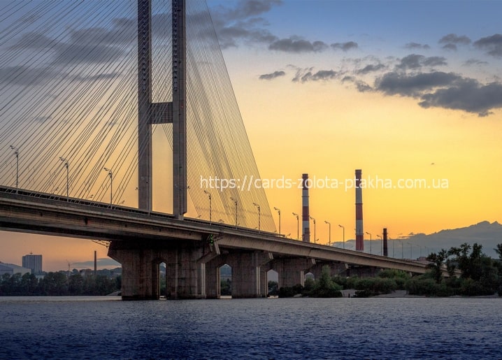 Cable-stayed bridge silhouetted against a golden sunset sky in Kyiv