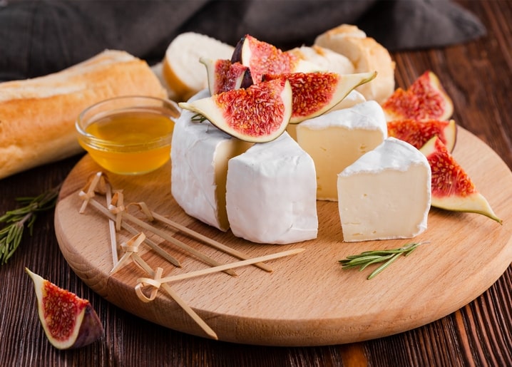Camembert mit frischen Feigenspalten und Honig, serviert mit Baguette und Rosmarin
