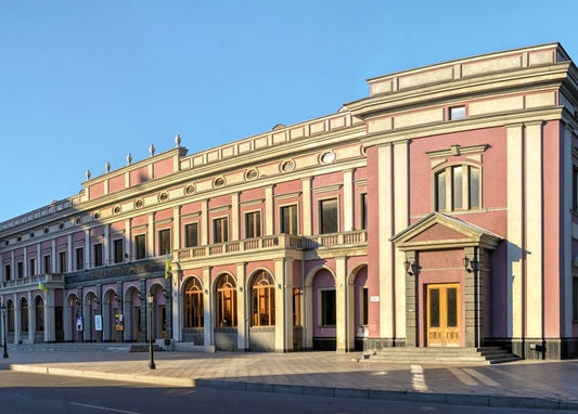 Pink neoclassical building with columns in Cherkasy at golden hour