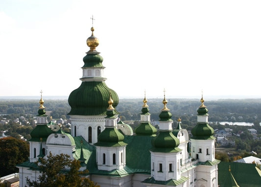 Вид з висоти на зелені бані собору над дахами та річкою Чернігова