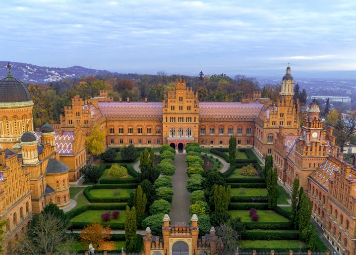 Aerial view of Chernivtsi University's red-brick towers and courtyard garden