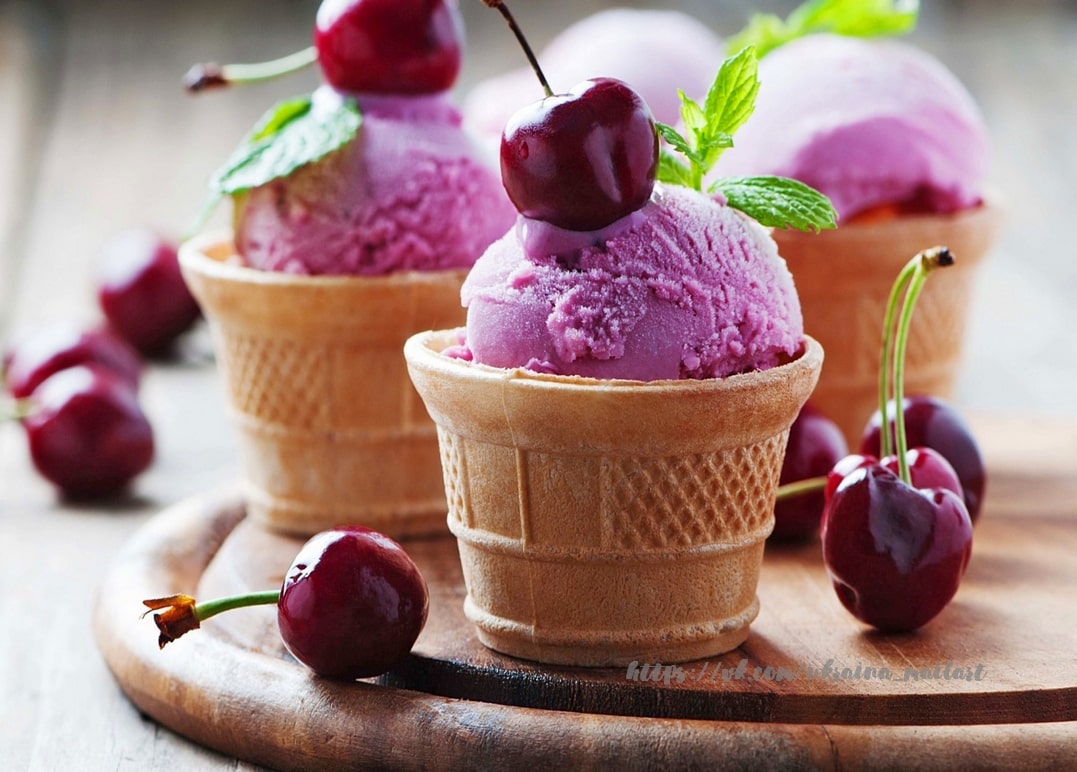 Kugeln Kirscheis in Waffelbechern mit frischen Kirschen und Minze