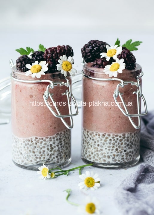 Zwei Gläser Chia-Pudding mit Brombeeren und Kamillenblüten