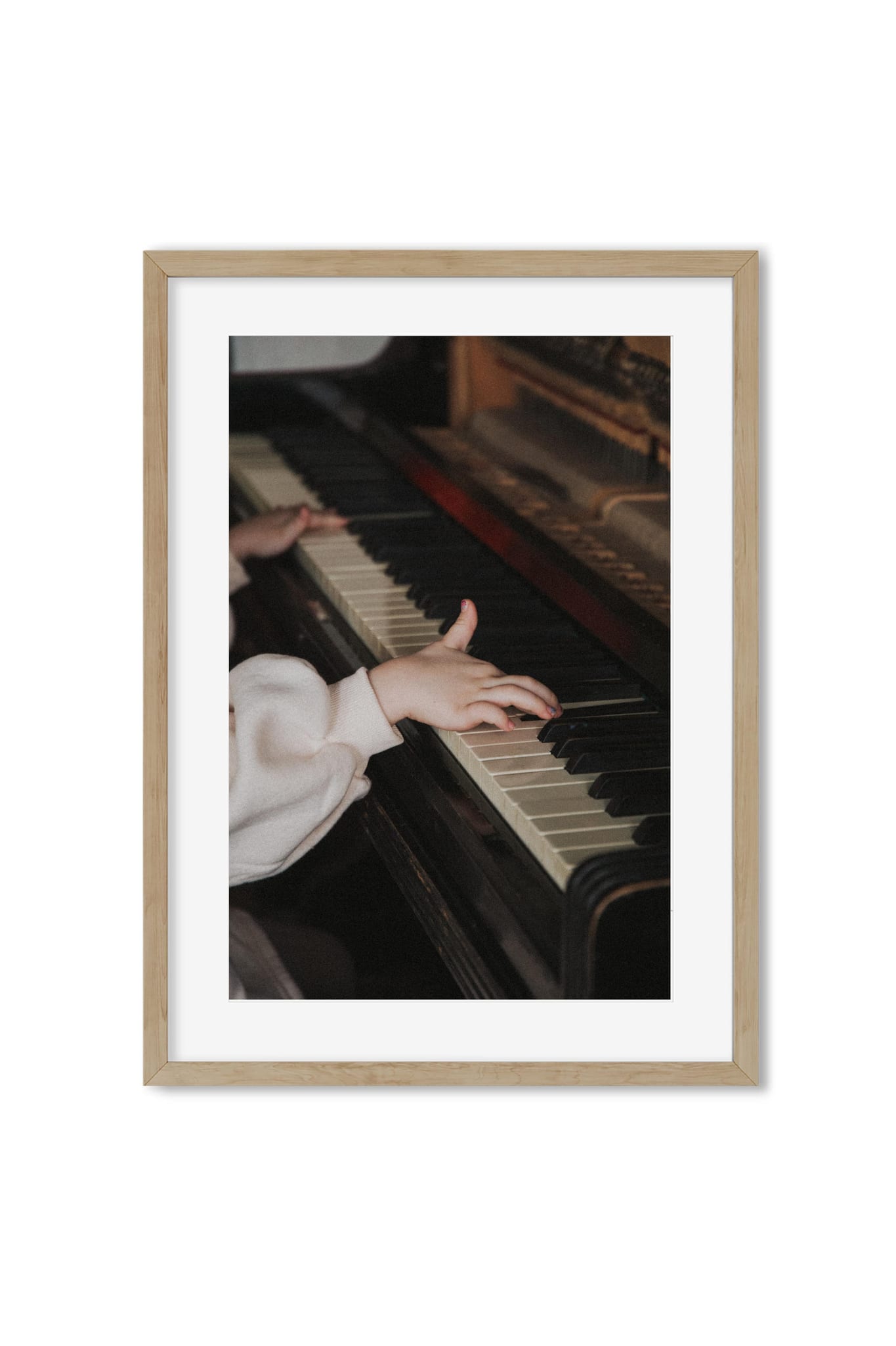 Close-up of a child's hand pressing keys on an old upright piano