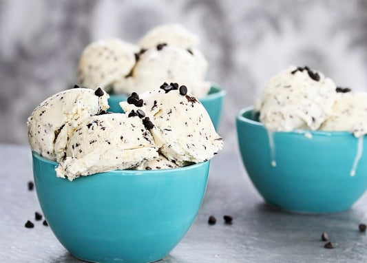 Kugeln Schokostückchen-Eis in türkisen Schälchen auf einer Marmorplatte