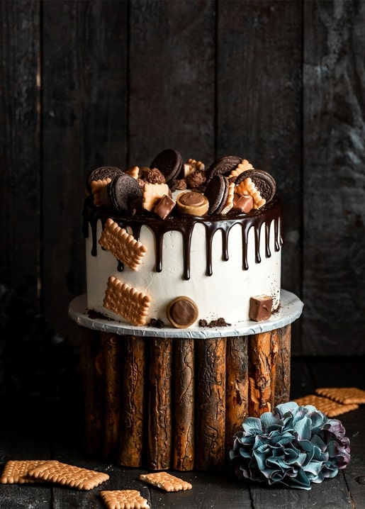 Schokoladentorte mit Oreo-Keksen, Waffelkeksen und Pralinen auf Holzstand