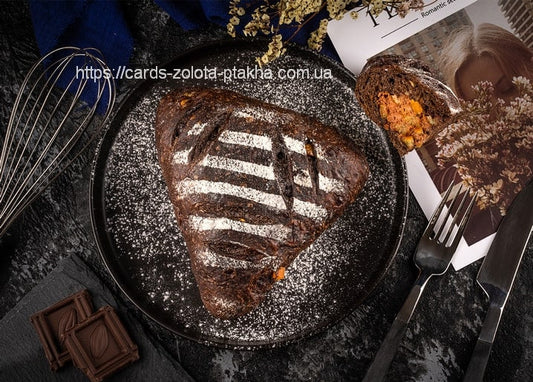 Dunkles Schokoladengebäck mit Puderzuckerstreifen auf schwarzem Teller