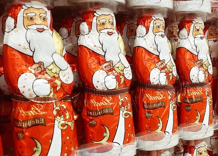 Rows of foil-wrapped chocolate Santa Claus figures decorated with stars and a candy cane