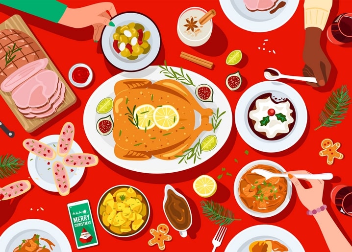 Top-down view of a Christmas dinner table with roast turkey, ham, gingerbread men, and a 'Merry Christmas' card.