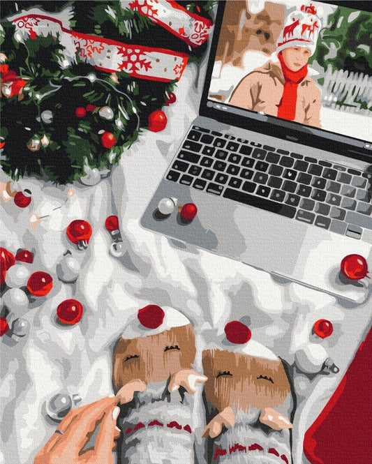 Flat Lay mit Weihnachts-Videoanruf, Adventskranz, Christbaumschmuck und lebkuchenförmigen Fäustlingen