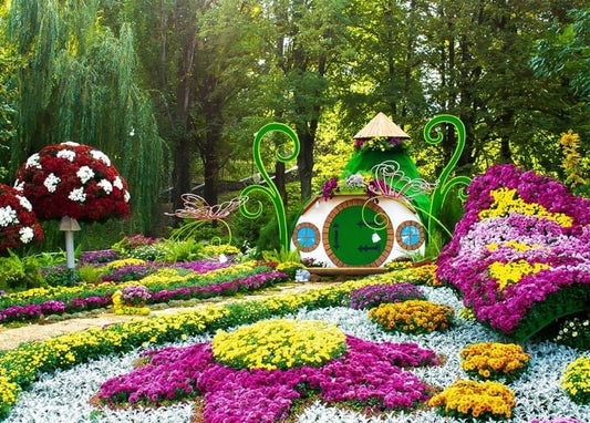 Hobbit-Gartenhaus umgeben von magenta- und gelbblühenden Chrysanthemen auf einer Kiewer Blumenschau