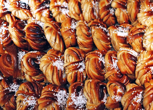 Reihen gedrehter Zimtschnecken mit Hagelzucker auf einem Backblech