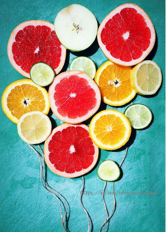 Grapefruit-, Orangen-, Zitronen-, Limetten- und Apfelscheiben wie Luftballons an Schnüren