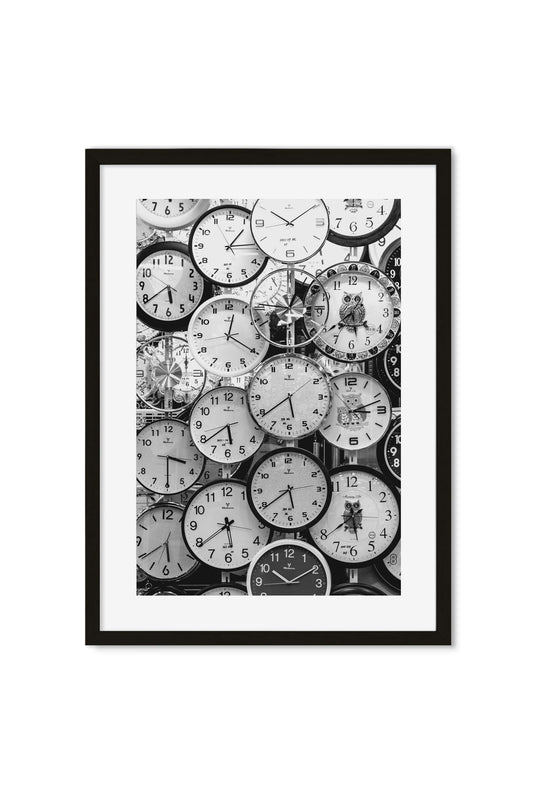 Black-and-white photo collage of dozens of overlapping clock faces, including one shaped like an owl