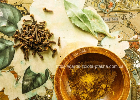 Whole cloves and dried bay leaves beside a wooden bowl of spice powder on vintage illustrated paper