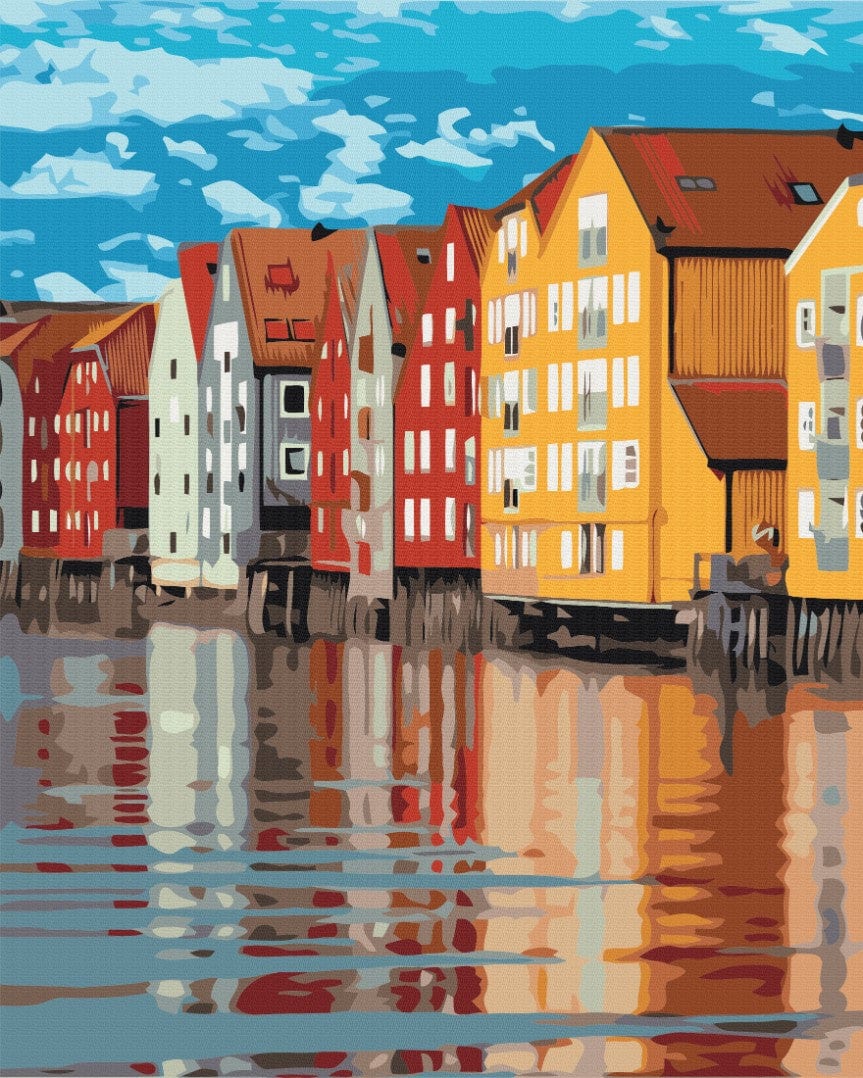 Yellow, red and white wooden houses on stilts reflected in blue water under a bright sky