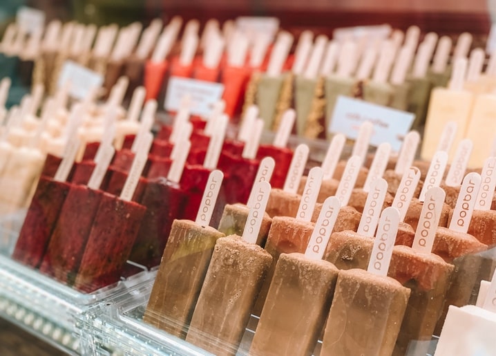 Reihen bunten Eis am Stiel in einer gläsernen Ladenvitrine
