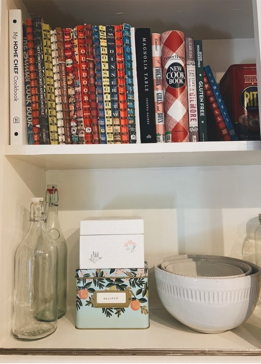 Кухонна полиця з кулінарними книгами та квітковою бляшанкою для рецептів
