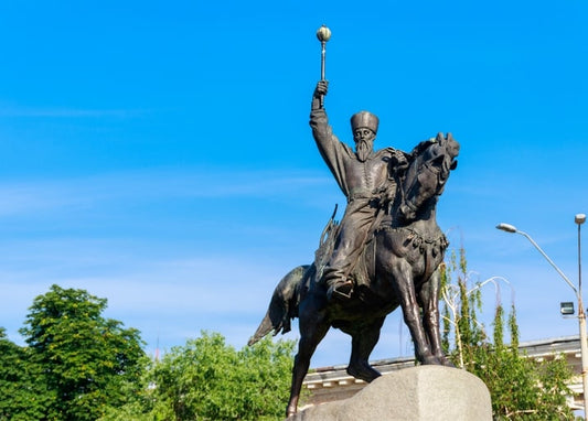 Бронзова кінна статуя козацького гетьмана з високо піднятою булавою на тлі синього неба