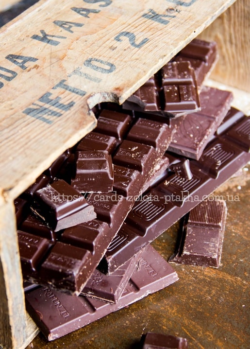 Dunkle Schokoladentafeln quellen aus einer alten Holzkiste mit der Aufschrift Netto 2 kg