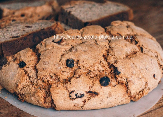 Rundes Roggenbrot mit Rosinen, im Hintergrund aufgeschnittene Brotscheiben