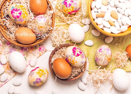 Eggs decorated with floral decoupage in a basket with straw, white eggs and almonds