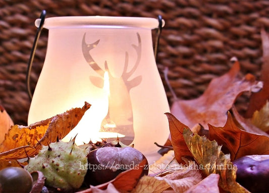 Frosted lantern with a stag silhouette glowing among chestnuts and autumn leaves