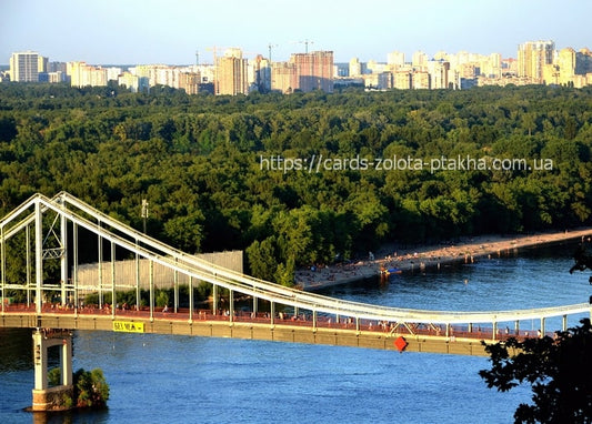 Suspension footbridge over the Dnipro River leading to a sandy beach